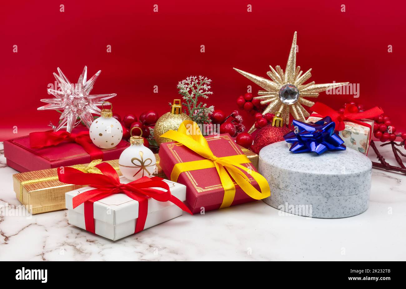 Christmas gift boxes isolated on marble table and red background Stock Photo