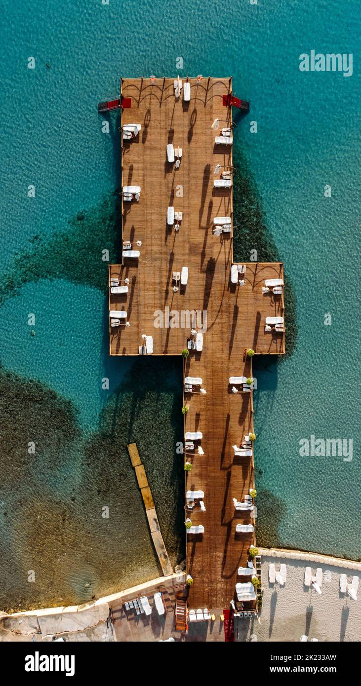 Aerial drone top view to the beach with white sand, pier with sunchairs and blue sea. Luxury summer vacation and resort. concept. Stock Photo
