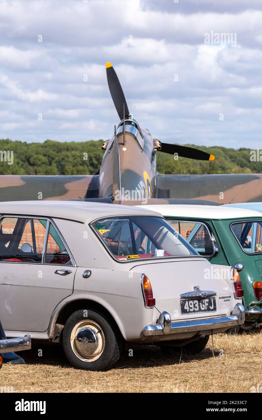 Classic cars and Hawker Hurricane Second World War fighter plane at the Little Gransden Air and Car show, Bedfordshire, UK. Morris 1100 classic car Stock Photo