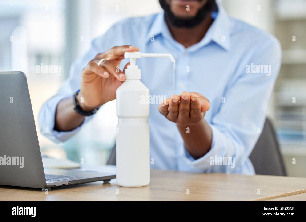 Covid, hand sanitizer or black businessman with laptop cleaning