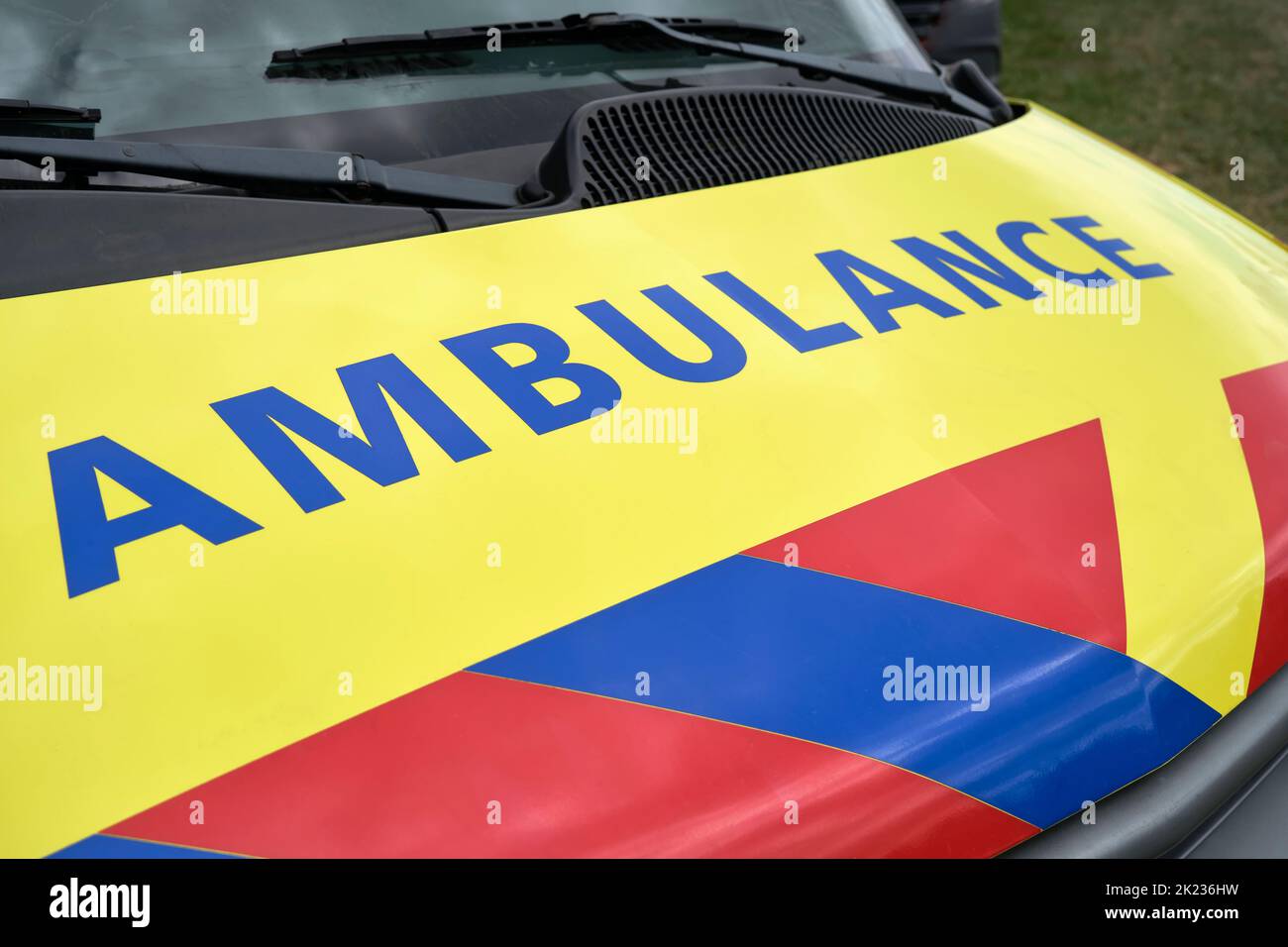 Dutch Ambulance logo on the hood of a parked medical van. Ambulance sign on yellow vehicle with red and blue stripes. Stock Photo