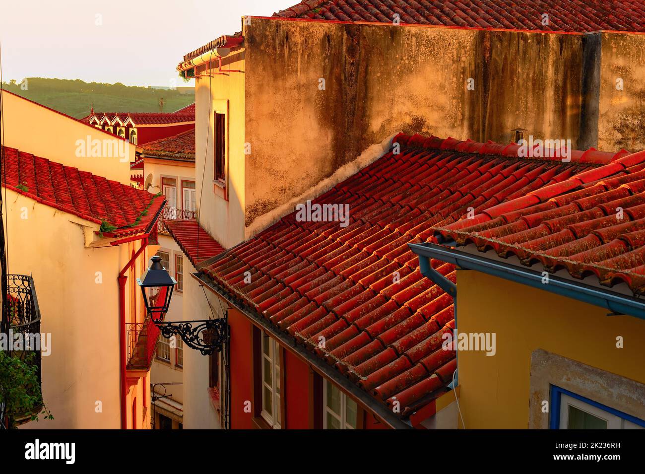 Narrow street with traditional architecture in susnet light, red rooftops, vintage lantern, Porto, Portugal Stock Photo