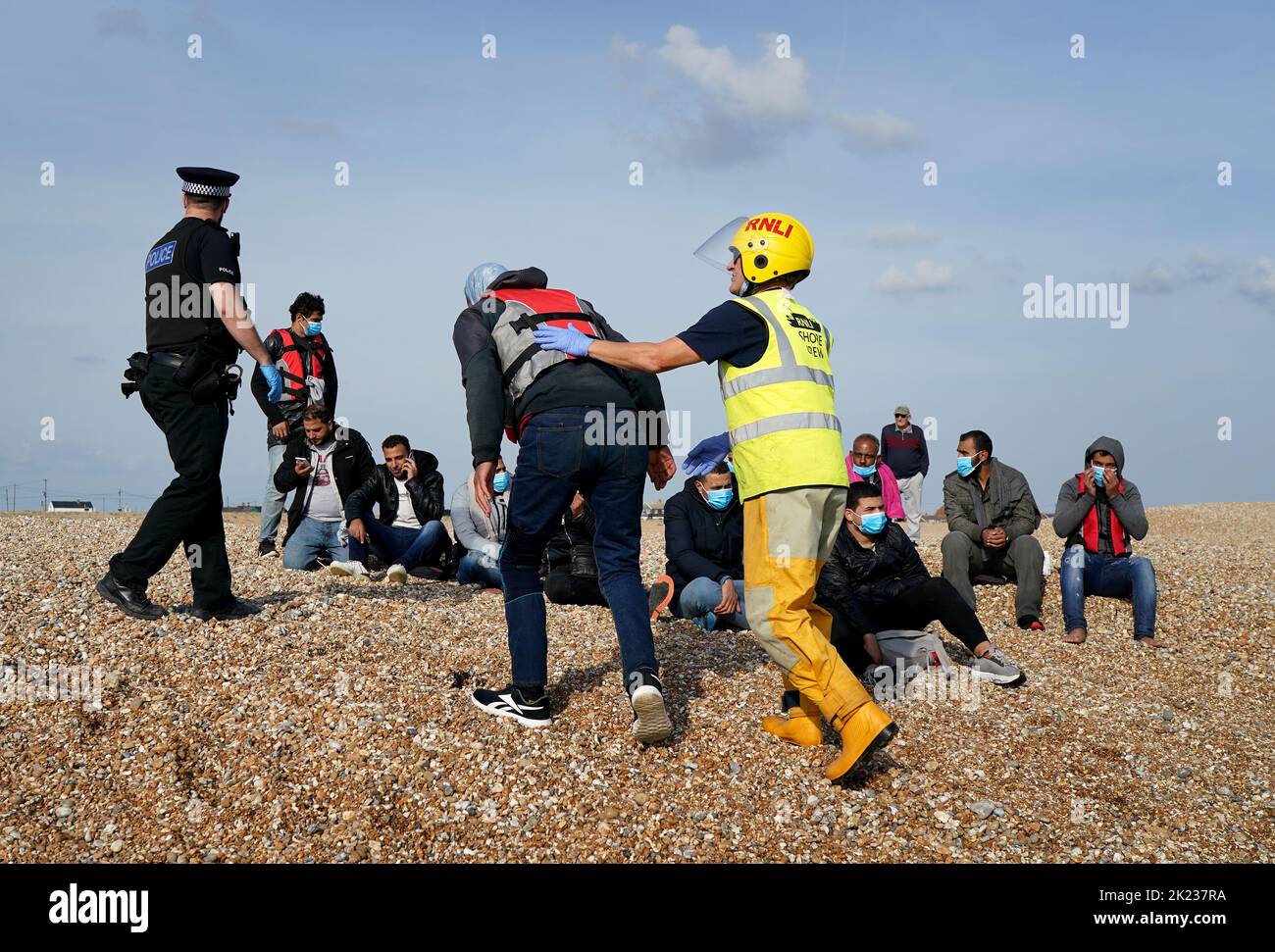 A man is helped to shore as a group of people thought to be migrants arrive in Dungeness, Kent, after being rescued in the Channel by the RNLI following following a small boat incident. Picture date: Thursday September 22, 2022. Stock Photo