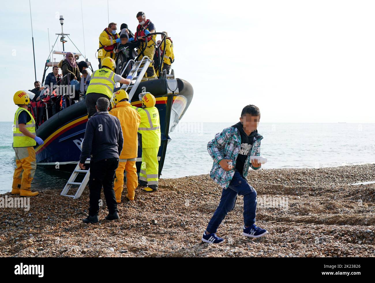 EDITORS NOTE Children's faces have been pixelated as the PA Picture Desk has been unable to gain the necessary permission to photograph a child under 16 on issues involving their welfare A young boy amongst a group of people thought to be migrants arrives in Dungeness, Kent, after being rescued in the Channel by the RNLI following following a small boat incident. Picture date: Thursday September 22, 2022. Stock Photo