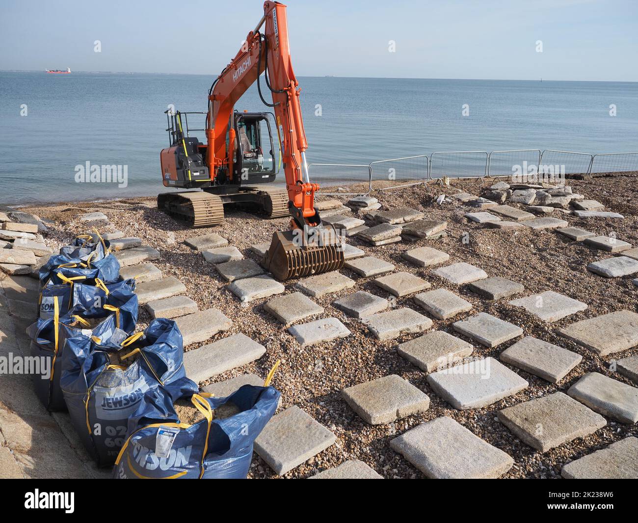 Sheerness, Kent, UK. 22nd Sep, 2022. Environment Agency contractors undertake repairs to the sea wall at Sheerness, Kent ahead of winter storms. A large number of flagstones were washed out by storms earlier this year in March and April, leaving the EA with a 'giant puzzle' of how to reinstate the flagstones they have recovered to fit the 'hole' in the sea wall. Credit: James Bell/Alamy Live News Stock Photo