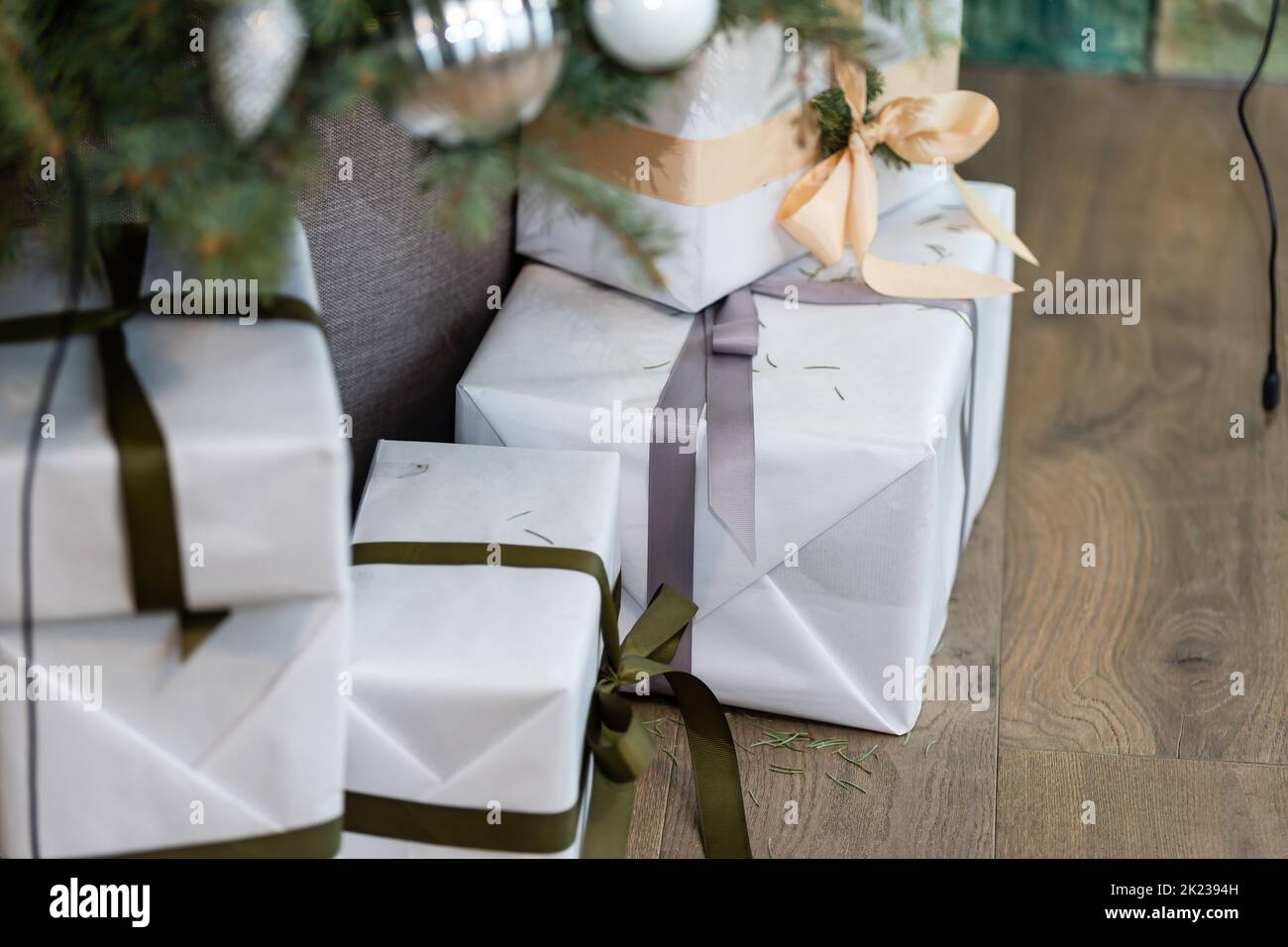 Beautiful Christmas gift boxes on floor near fir tree in room Stock ...