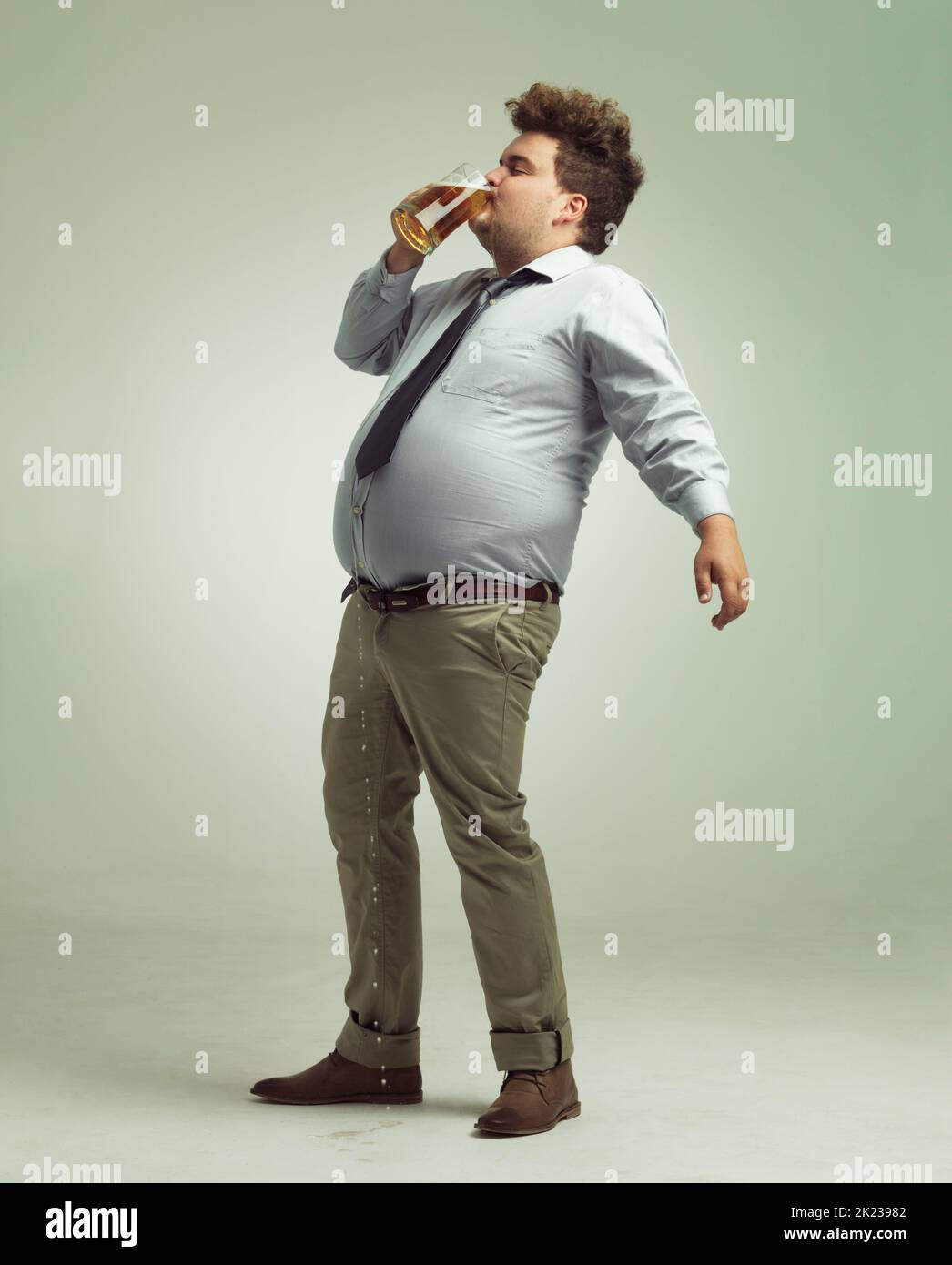 Its so good when it hits your lips. an overweight man downing a pint of