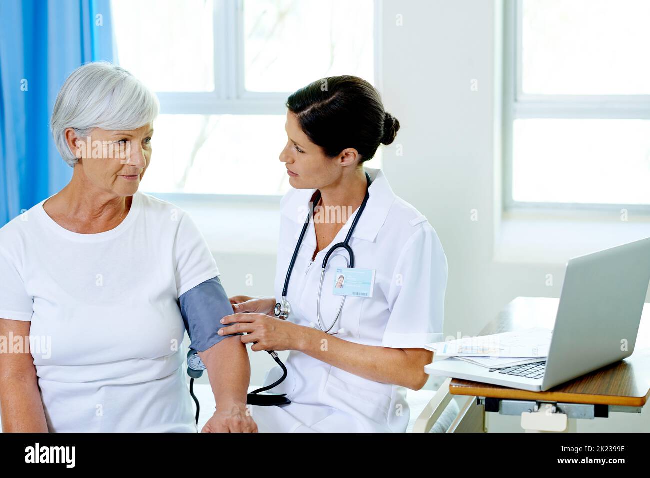 This wont hurt at all. a beautiful young female doctor testing a senior patients blood pressure. Stock Photo