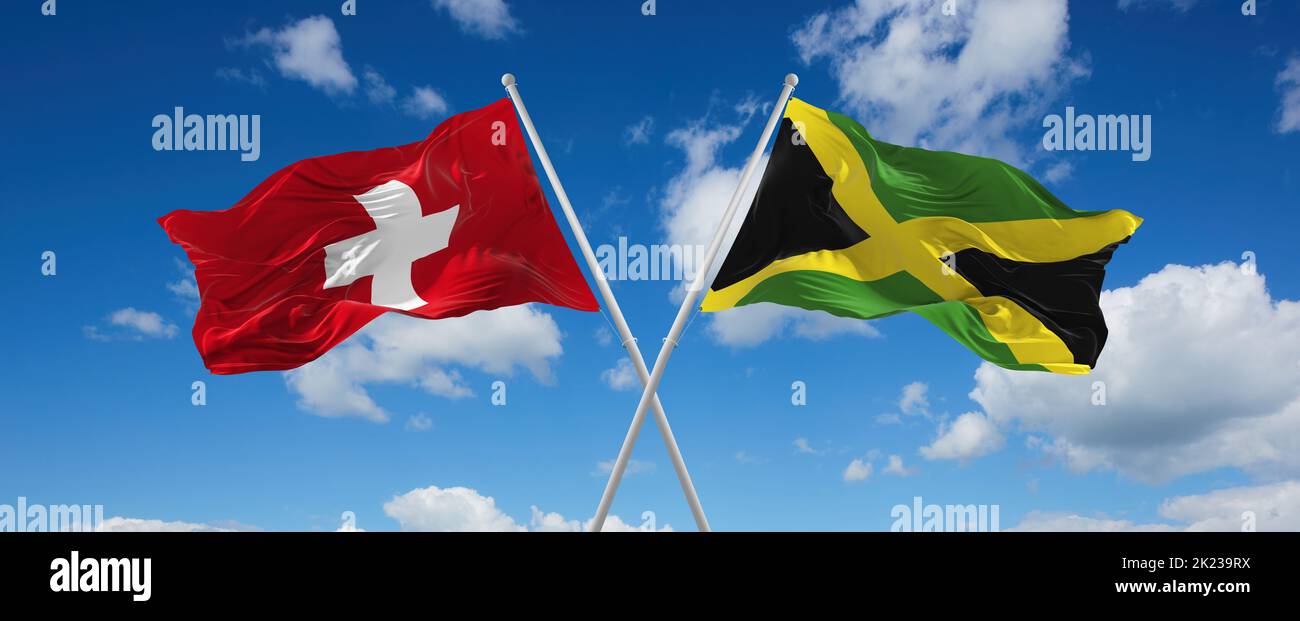 two crossed flags Jamaica and Switzerland waving in wind at cloudy sky ...