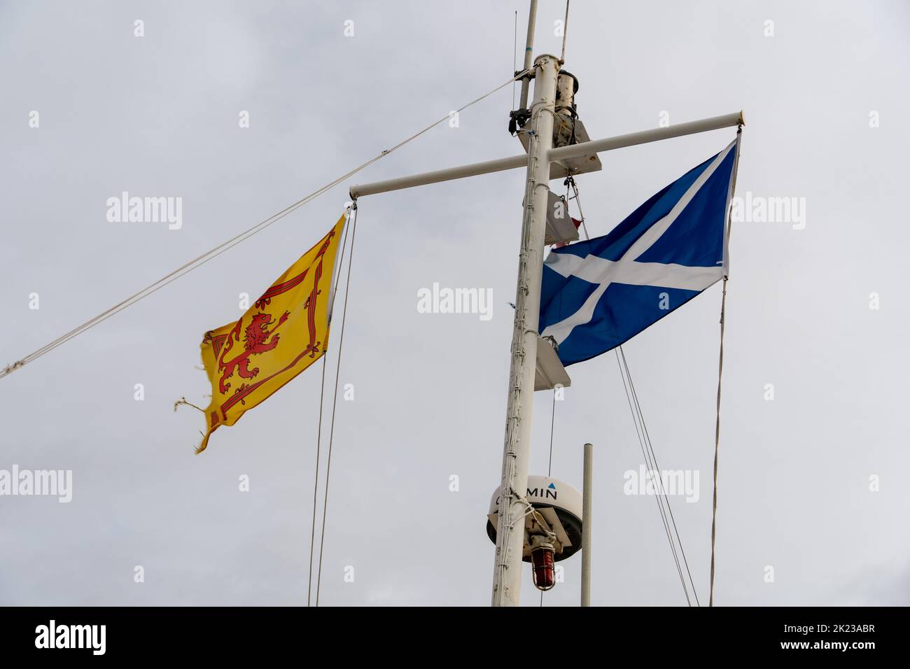 Two Scottish flags - The Saltire and the Royal Banner of Scotland on a boat in Scotland, UK. Stock Photo