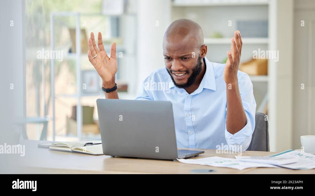 Stressed, upset and frustrated black businessman on a work conference call on a laptop. Angry, African and corporate manager with company documents on Stock Photo