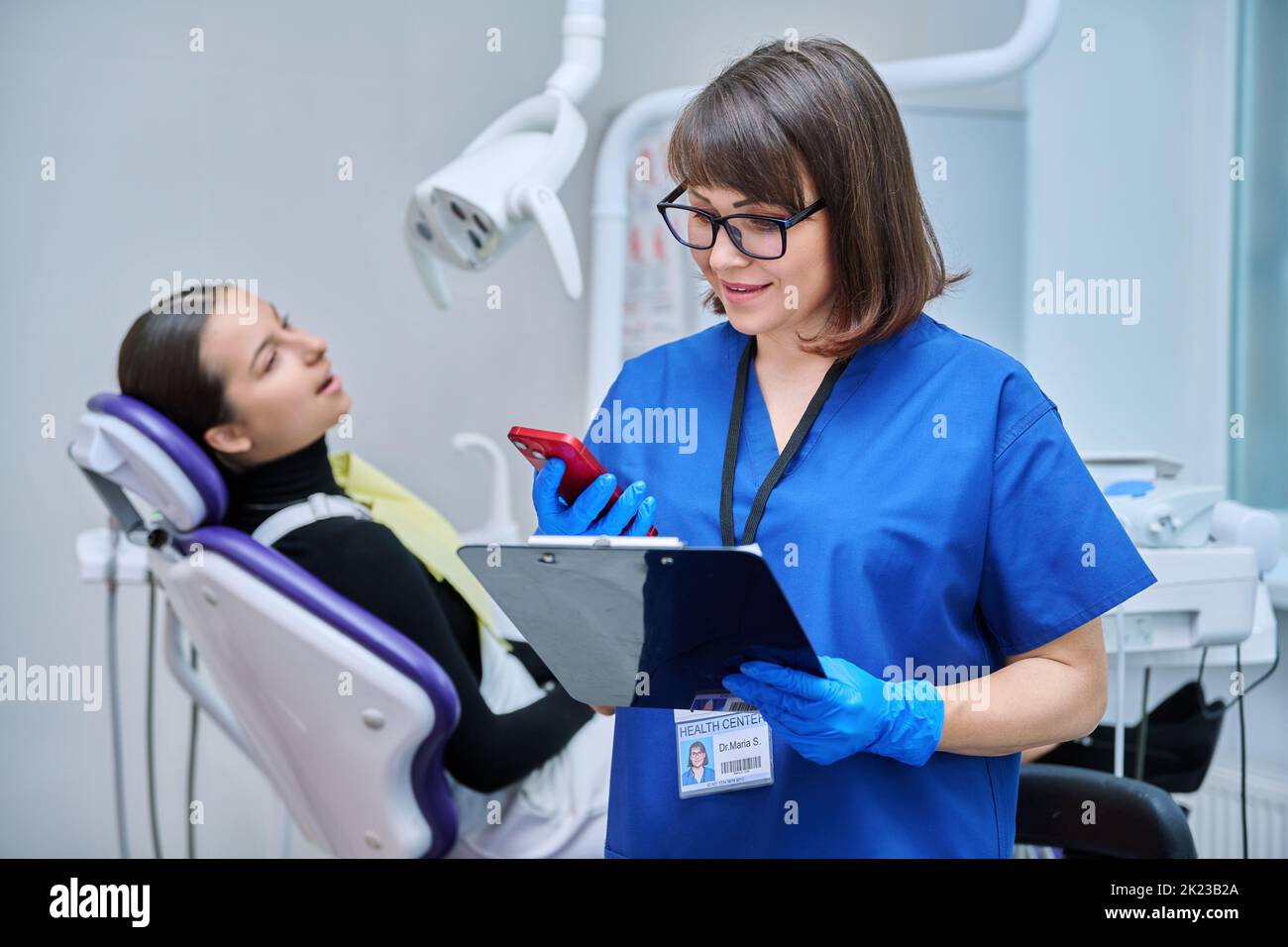Female dentist, nurse doctor with clipboard phone in dental office Stock Photo Alamy
