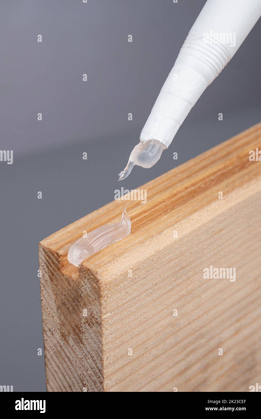 applying silicone to wood plank closeup, gluing wooden furniture. High quality 4k footage. Stock Photo