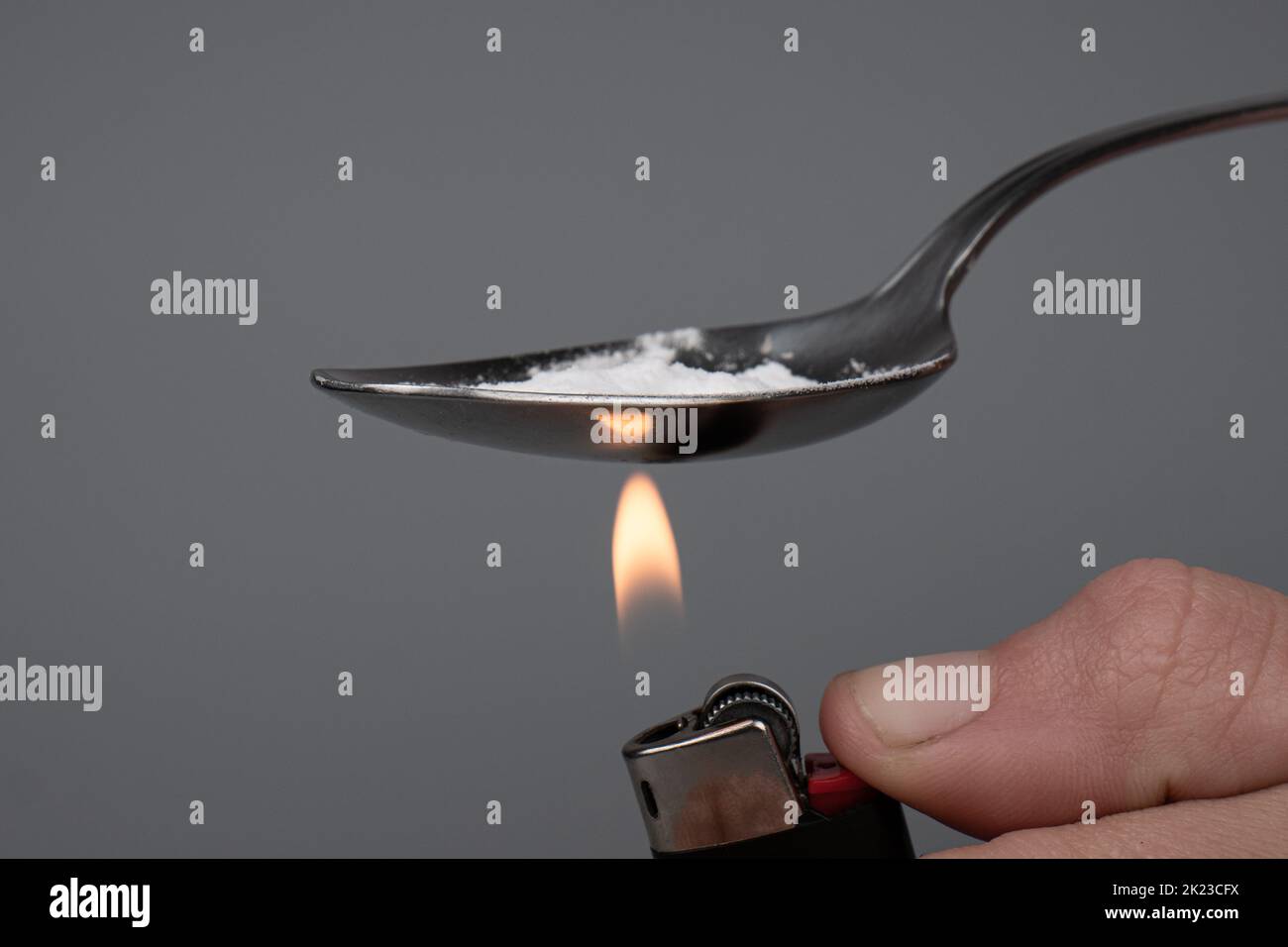 cooking with a lighter a narcotic substance on a spoon, boiling crystal drugs. Stock Photo