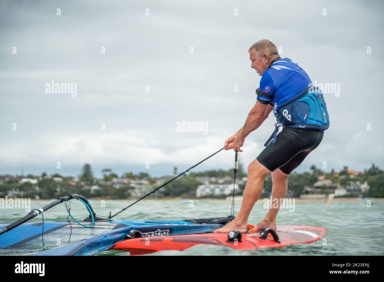 A retired senior man competes in a New Zealand national windsurfing