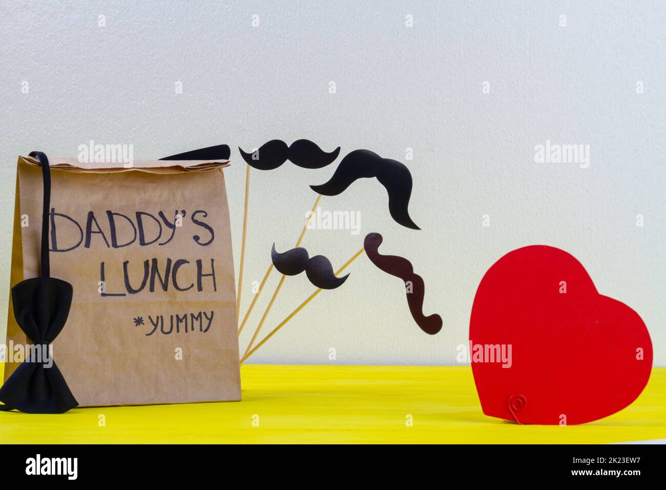 Paper bag for daddy on white background. Red heart and moustache. Stock Photo