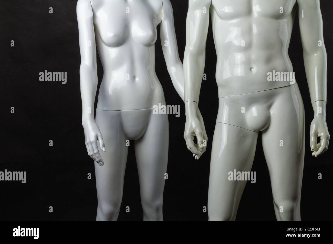 Holding hands of male and female mannequins. Isolated on black background. Stock Photo