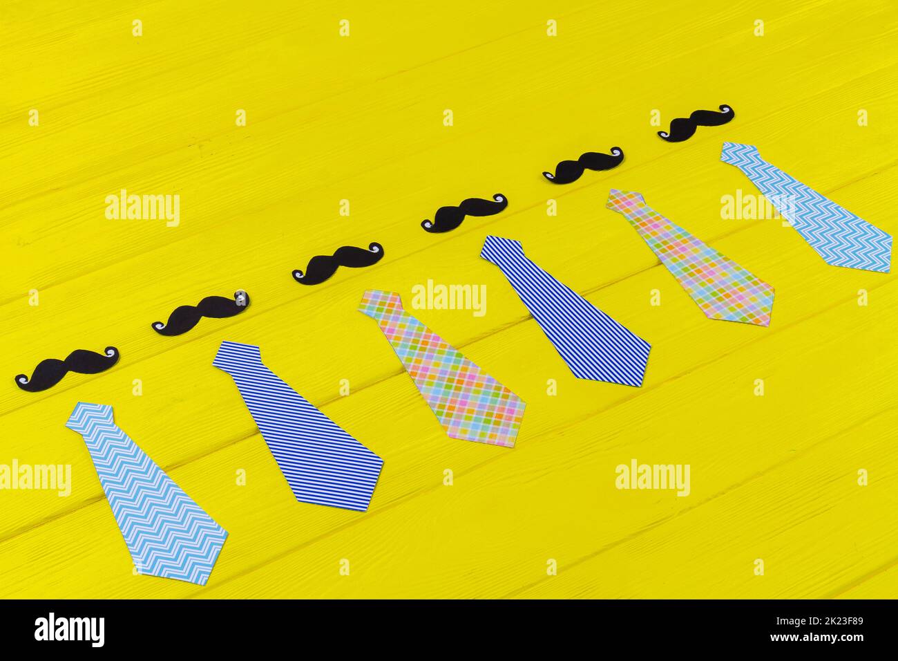 Mens neckties and moustaches on yellow desk. Fathers day concept. Stock Photo