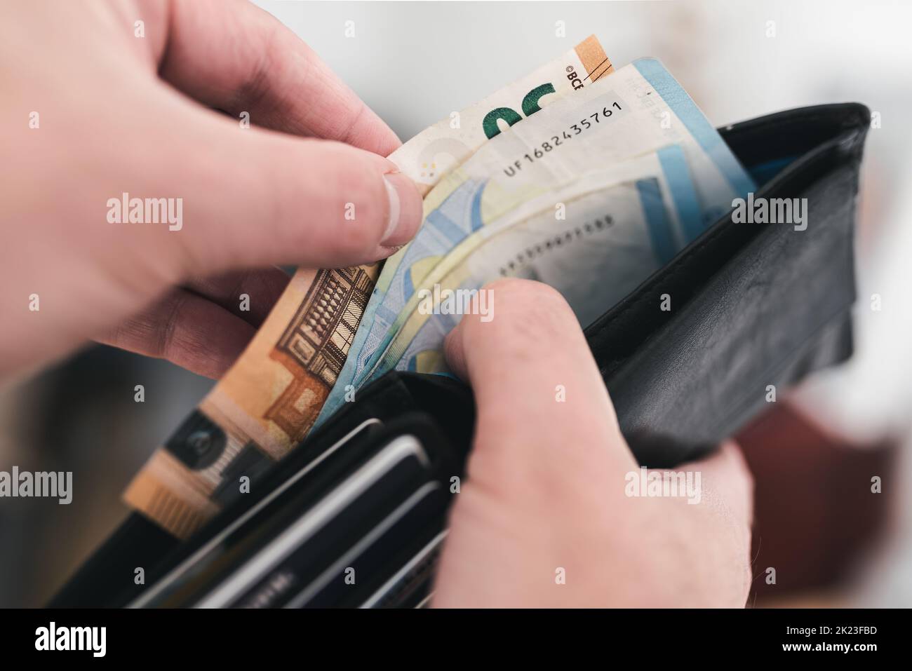 close-up view of hands taking money out of a wallet, spending cash concept Stock Photo