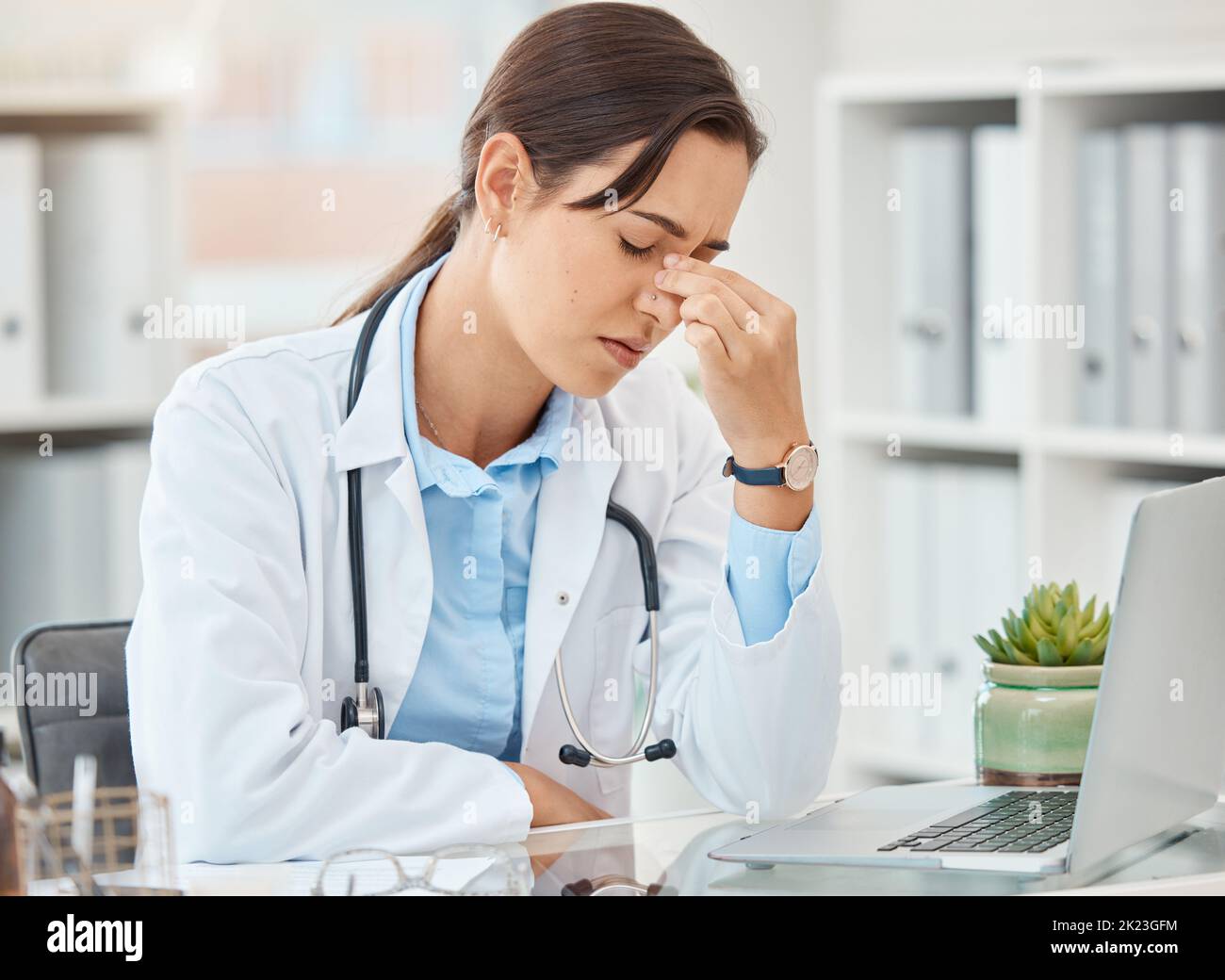 Headache pain, doctor stress and burnout from hospital work on laptop