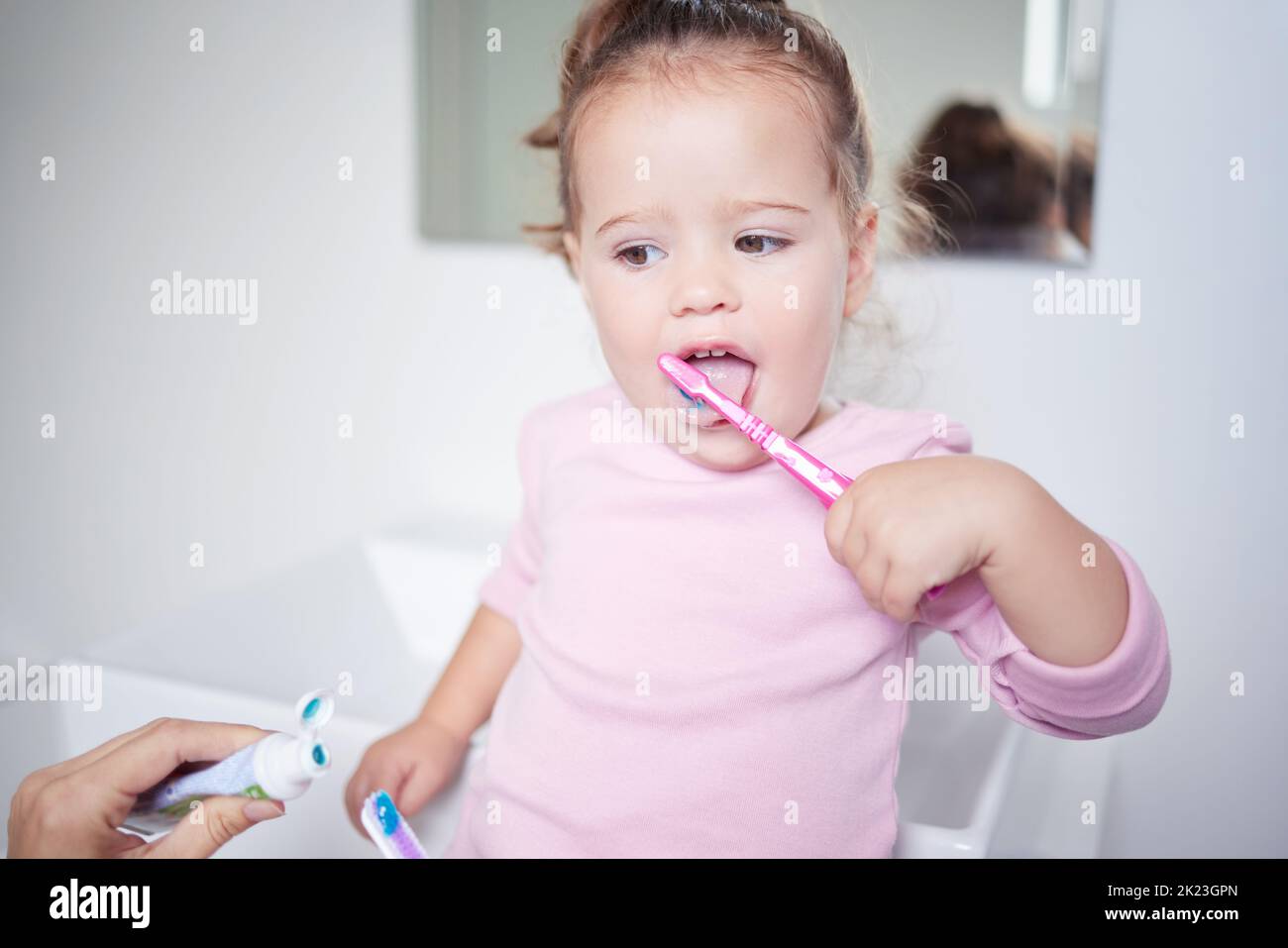 Baby learning to brush her teeth, dental and oral hygiene. Toothbrush, toothpaste and brushing
