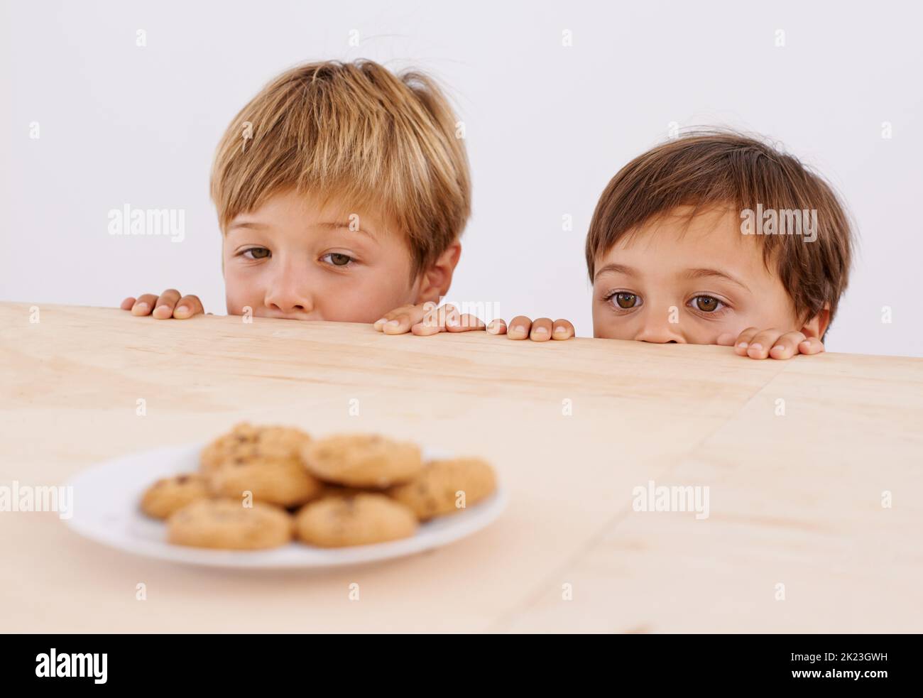 Theyre thinking about it. Two adorable young boys peeking out of a ...