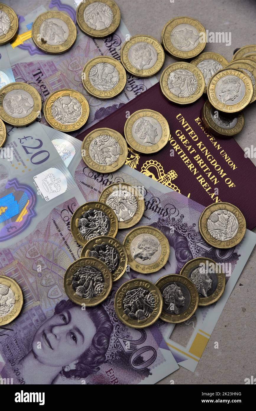 Uk sterling, twenty pound notes and one pound coins pictured. Uk and European British passports and Turkish Lire. Can be used for travel, inflation. Stock Photo