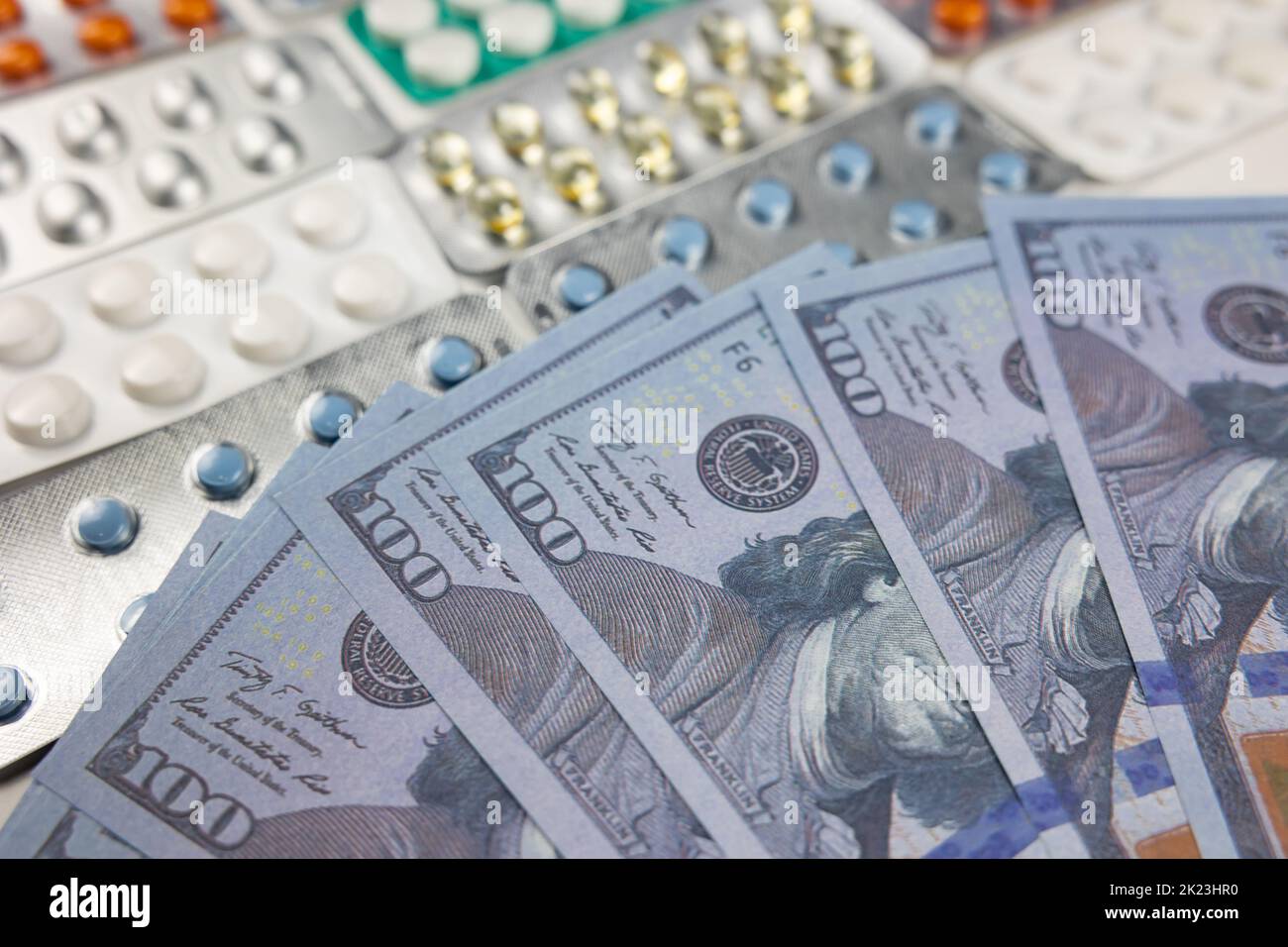 Health insurance cost in USA concept photo. US dollars and pills. American health care system concept. Stock Photo