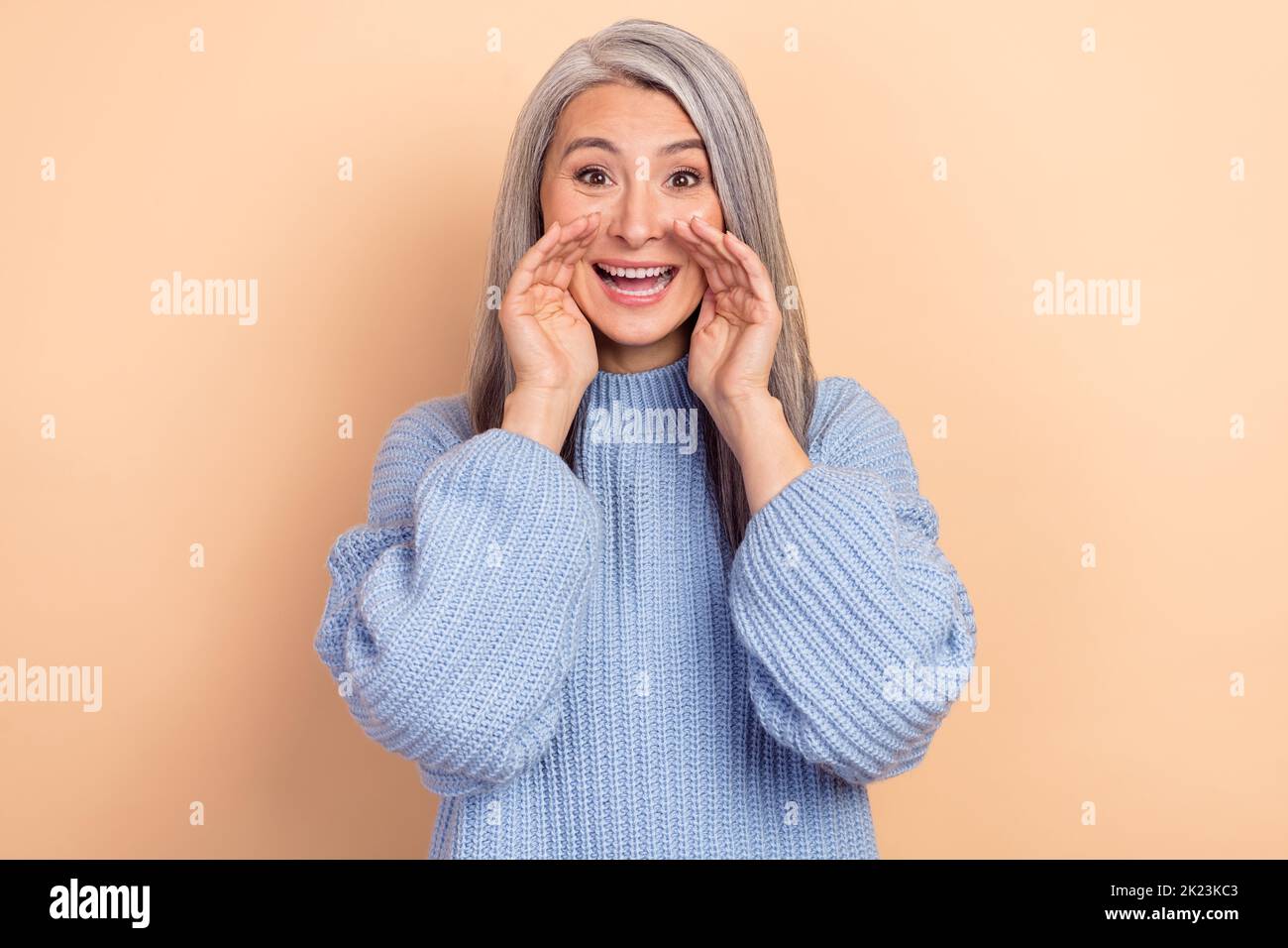 Photo of good mood overjoyed female tell you latest news screaming about advertisement isolated on beige color background Stock Photo