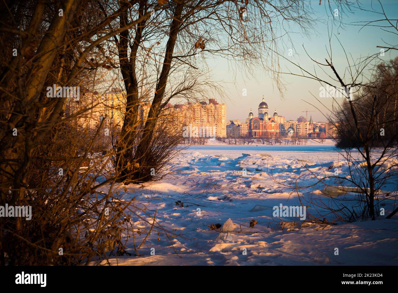 The modern Cathedral of Intercession of the Mother of God, with golden domes, close to the frozen Dnieper River at dawn Stock Photo