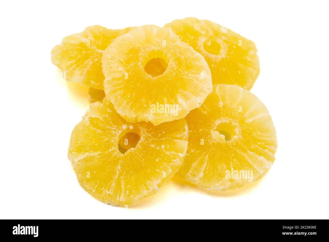 Dried pineapple slice isolated on white background. Dried fruit in sunlight. close up Stock