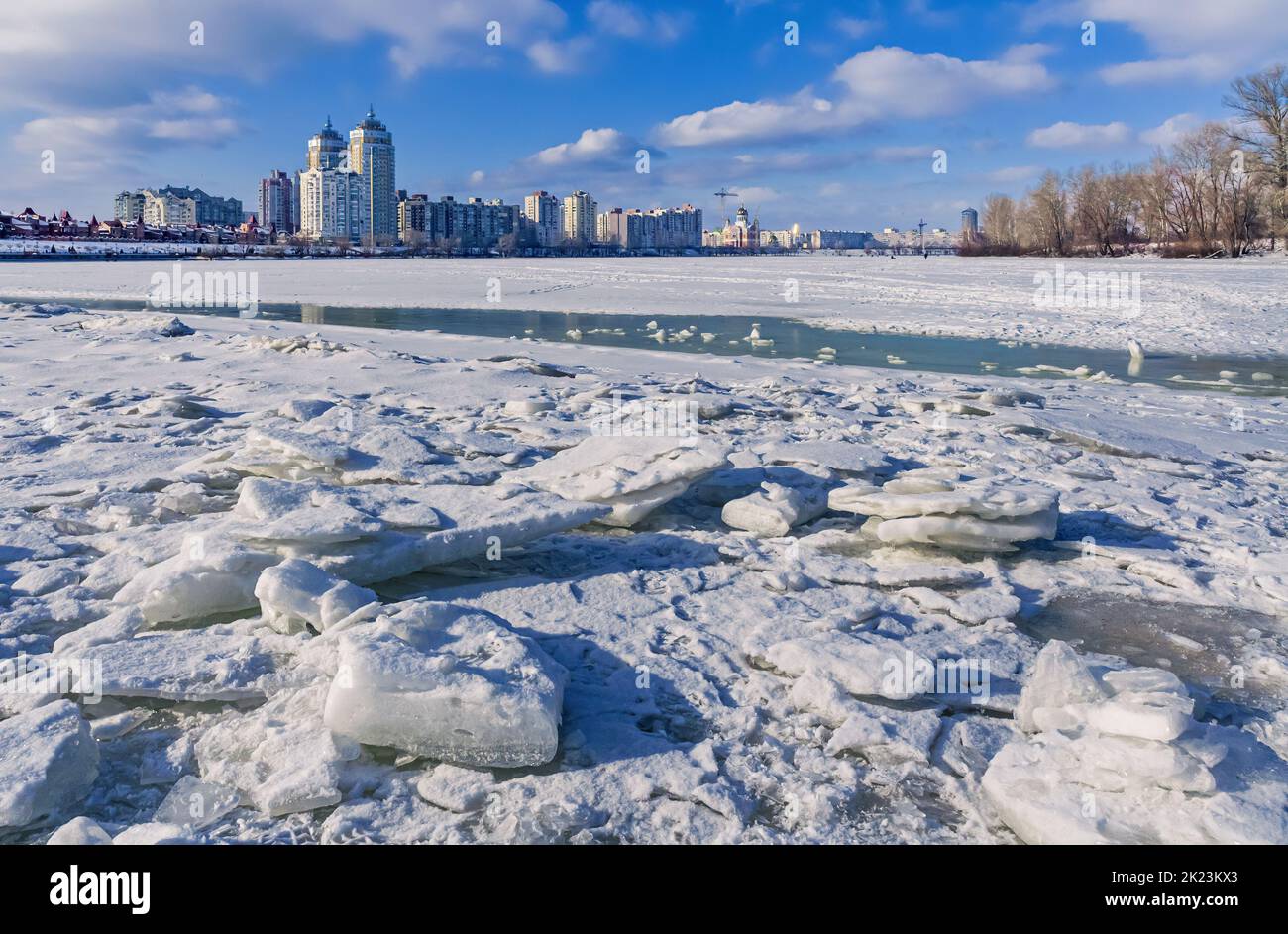 The Dnieper River is covered by ice and snow. The city district of Obolon appears in the background Stock Photo