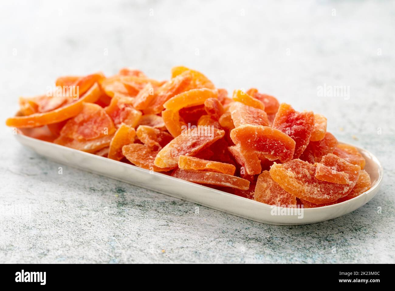Dried papaya slice on gray background. Dried fruit in sunlight. close