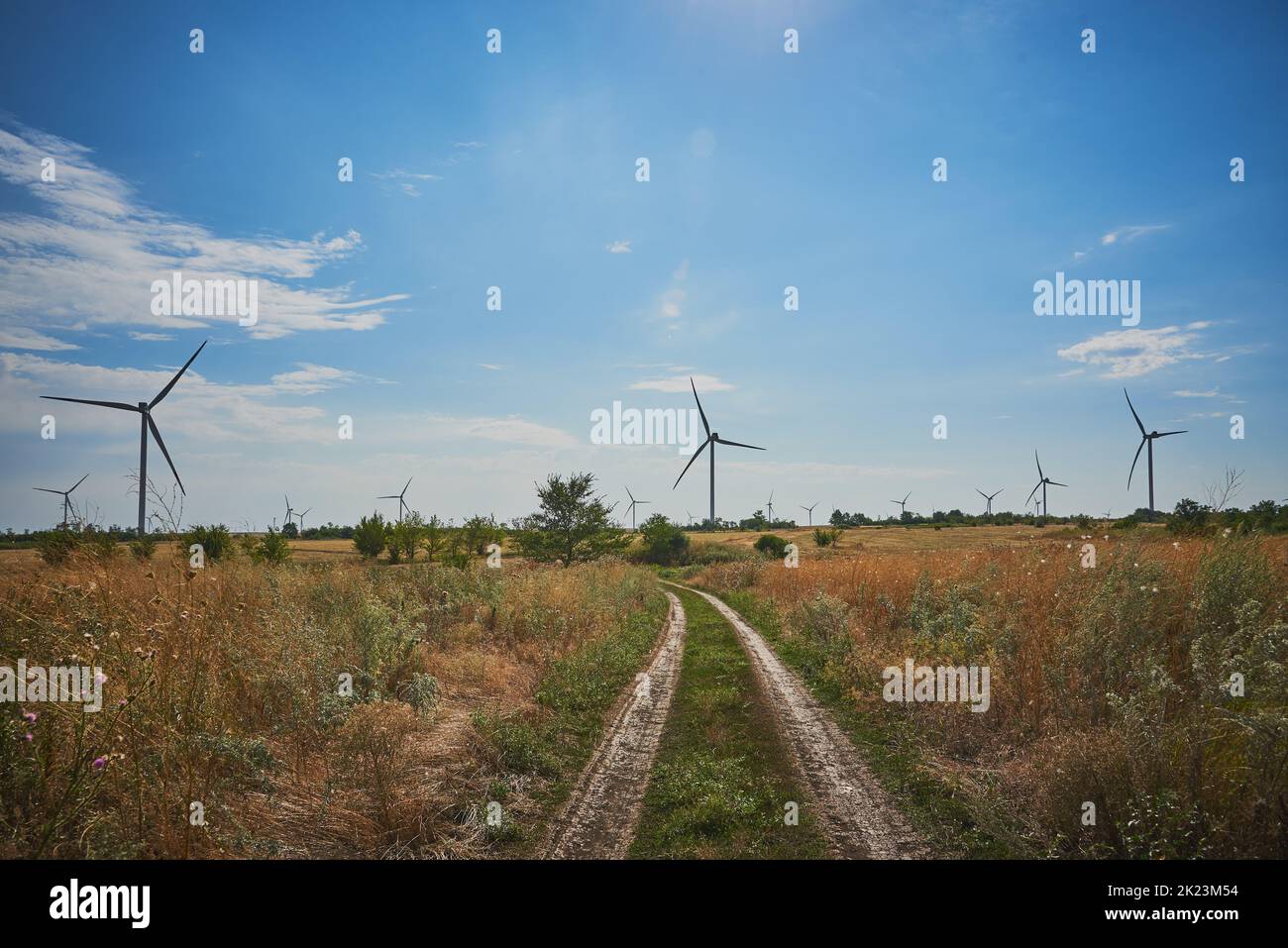 Dirt road in fields where there are wind turbines. Stock Photo