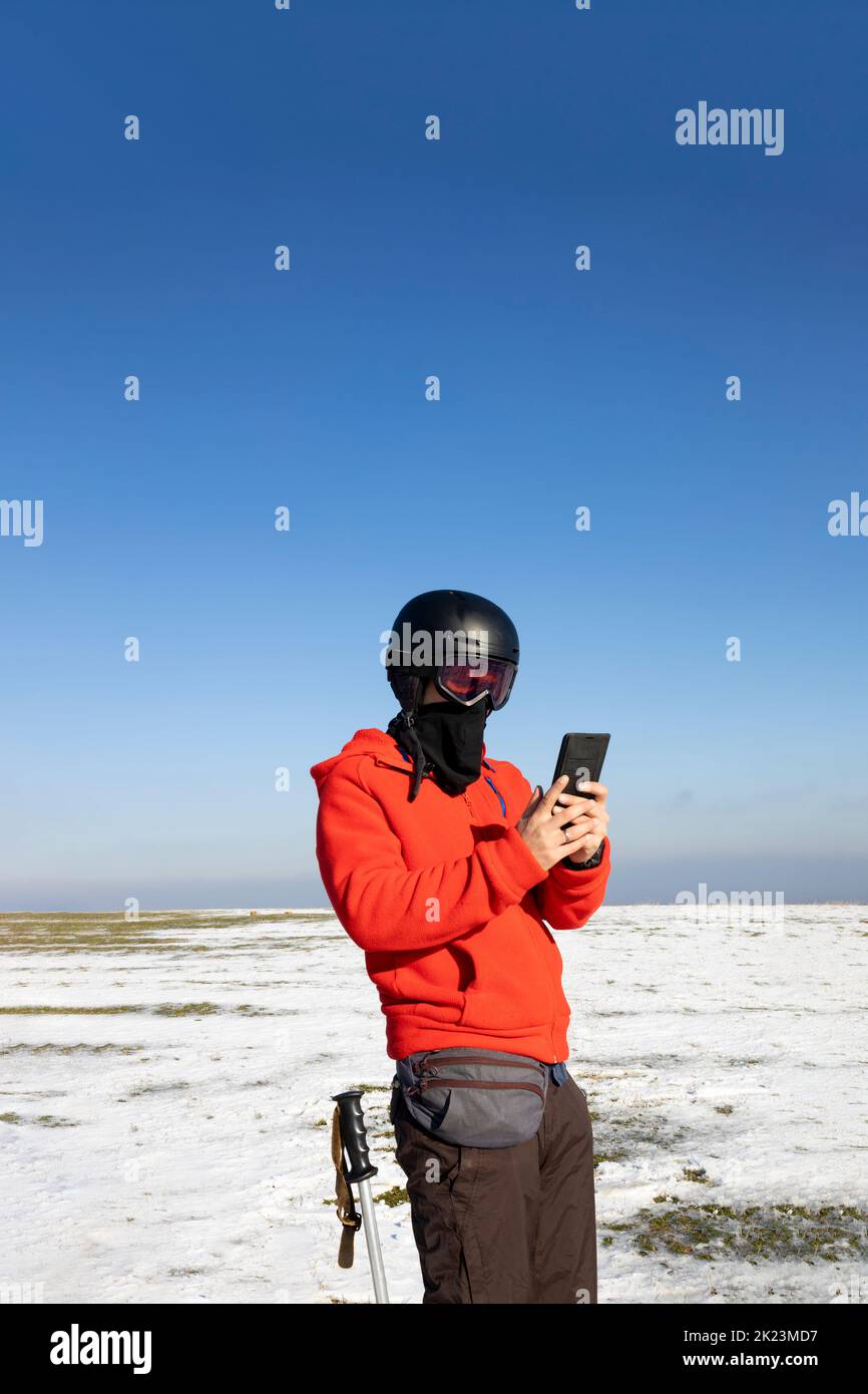 Skier using his smartphone in the mountains Stock Photo