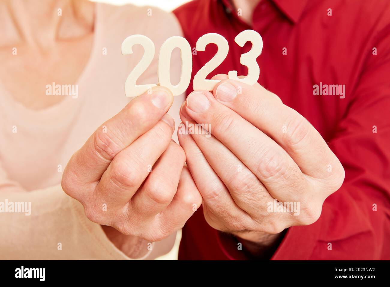Two senior hands show the year 2023 as a number Stock Photo