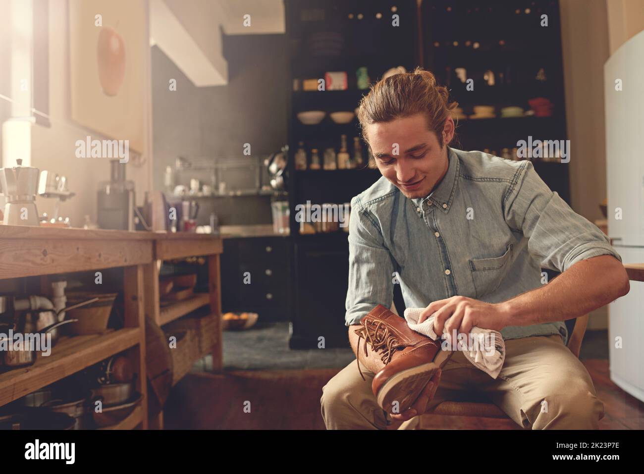 Keeping his shoes clean. a handsome young man cleaning his shoes in the