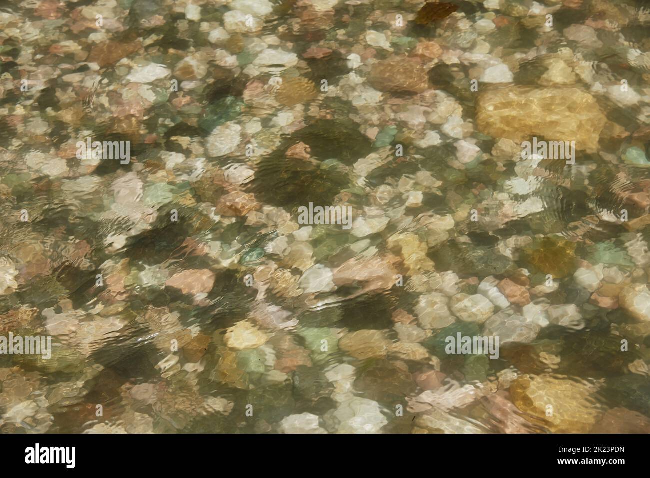 A fragment of a mountain river. Colorful stones under the water. Stock Photo