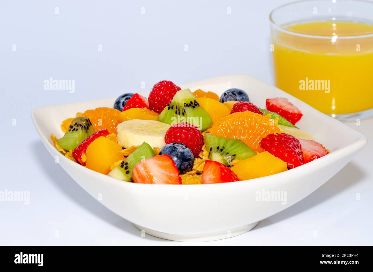 Healthy fresh fruit salad in a bowl with an orange juice for breakfast Stock Photo