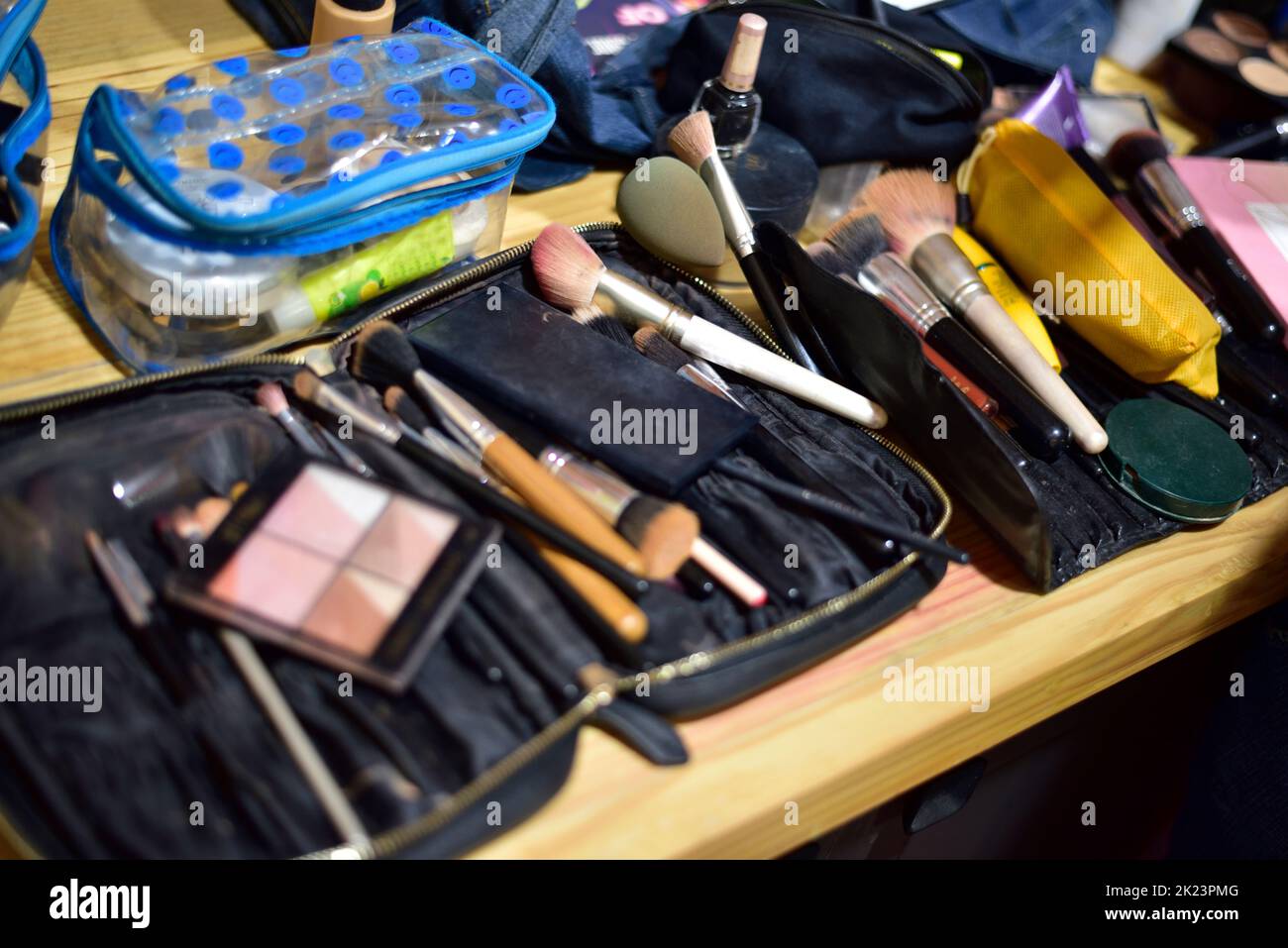 Makeup kits laying down on table haphazardly Stock Photo