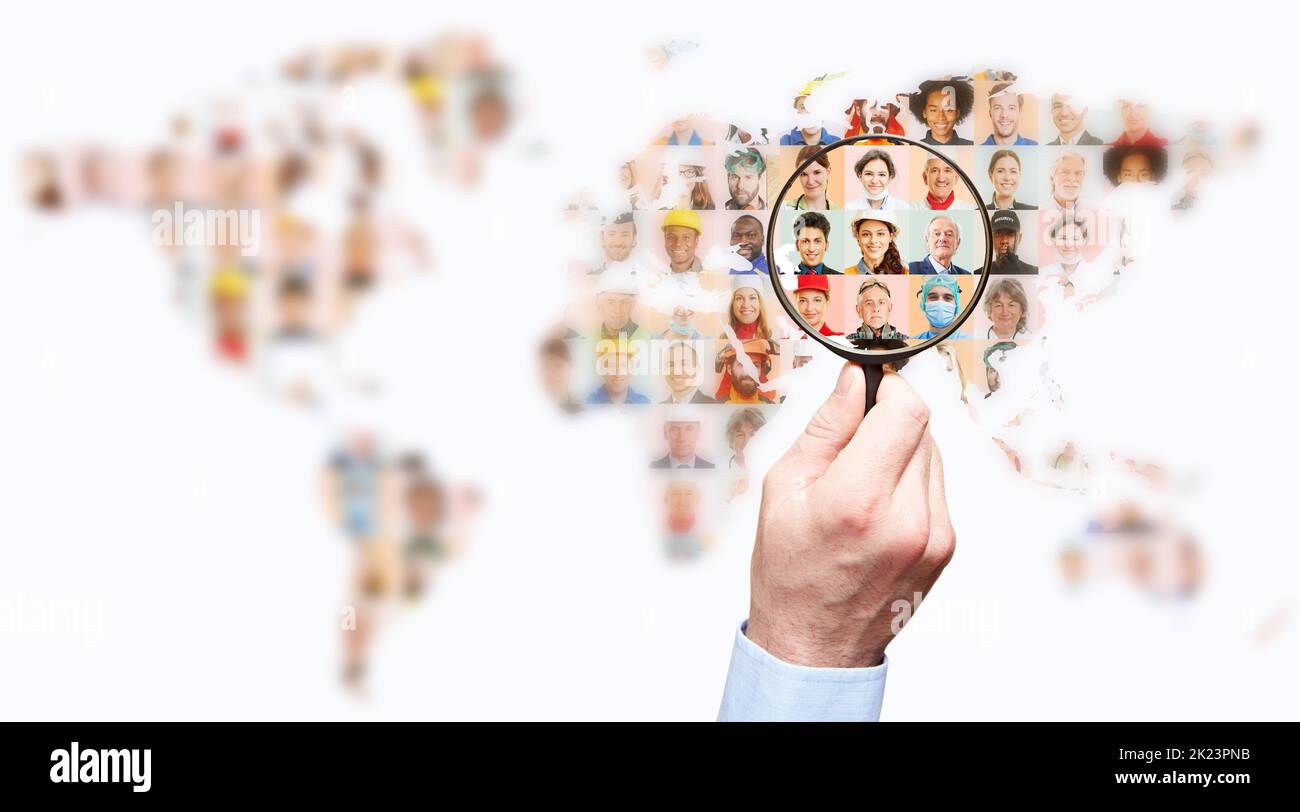 Hand with magnifying glass searching for suitable staff on world map as global labor market concept Stock Photo