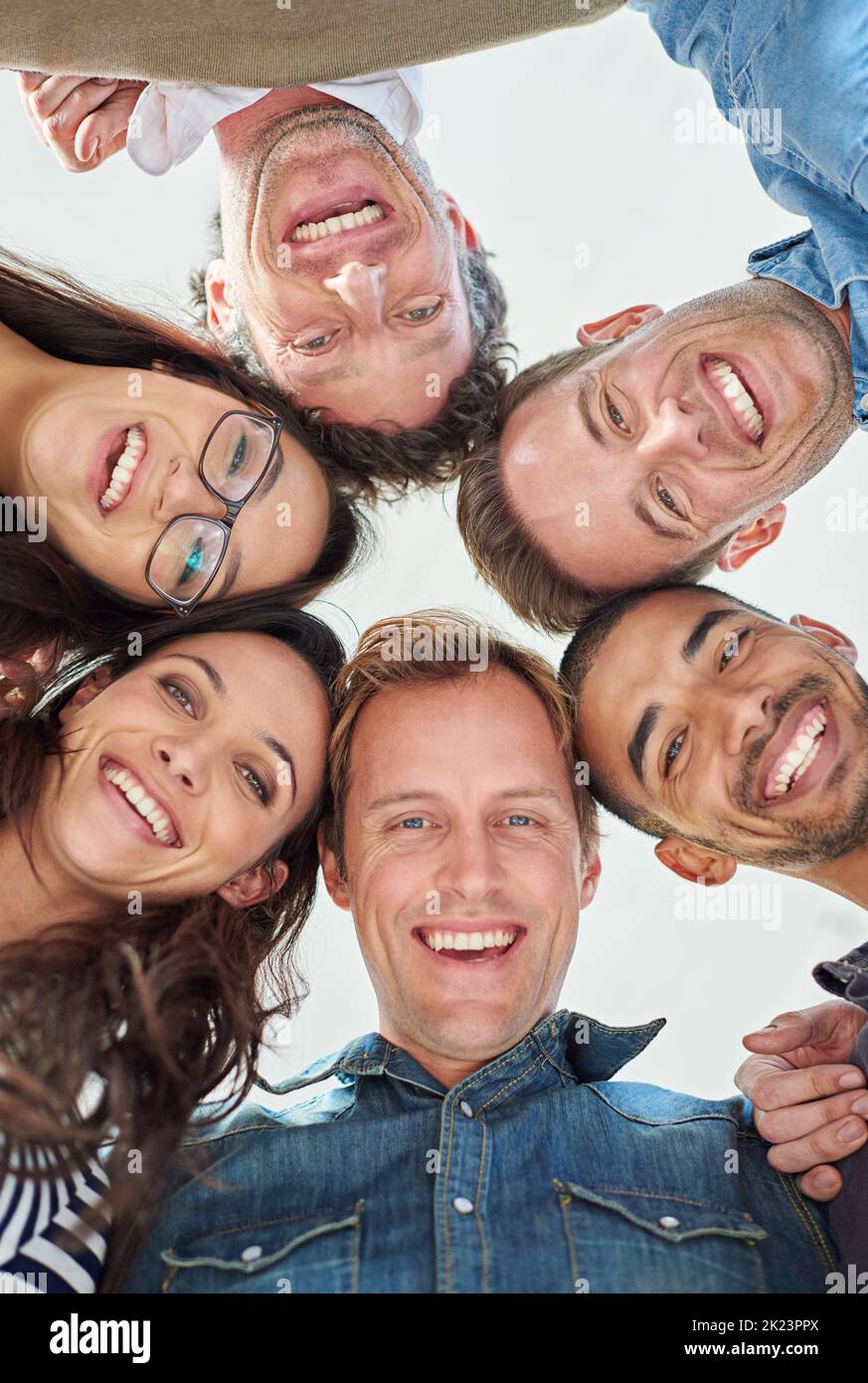 Winning with our positive attitude. Cropped low angle shot of six people putting their heads together in a circle. Stock Photo