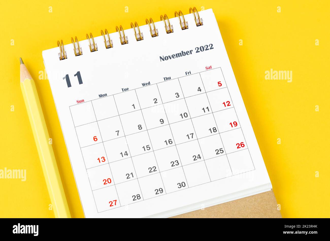November 2022 Monthly desk calendar for 2022 with pencil on yellow background. Stock Photo