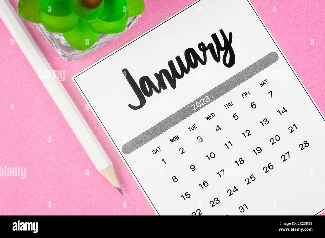 January 2023 Monthly calendar for 2023 year with pencil on pink background. Stock Photo