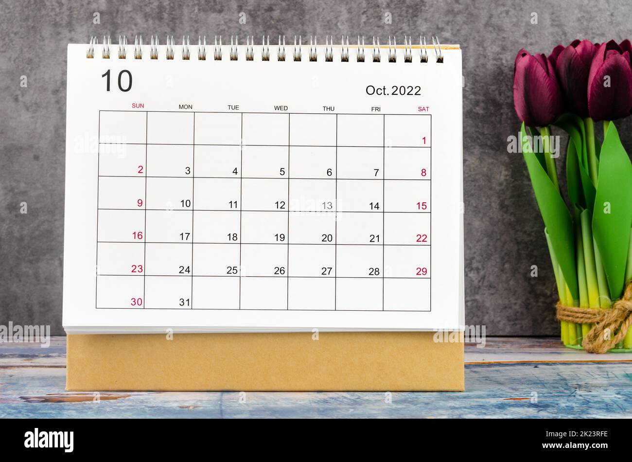 October 2022 Desk calendar for 2022 year with flower on wooden background. Stock Photo