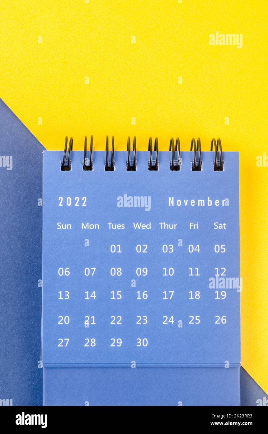 November 2022 Monthly desk calendar for 2022 year on blue and yellow background. Stock Photo