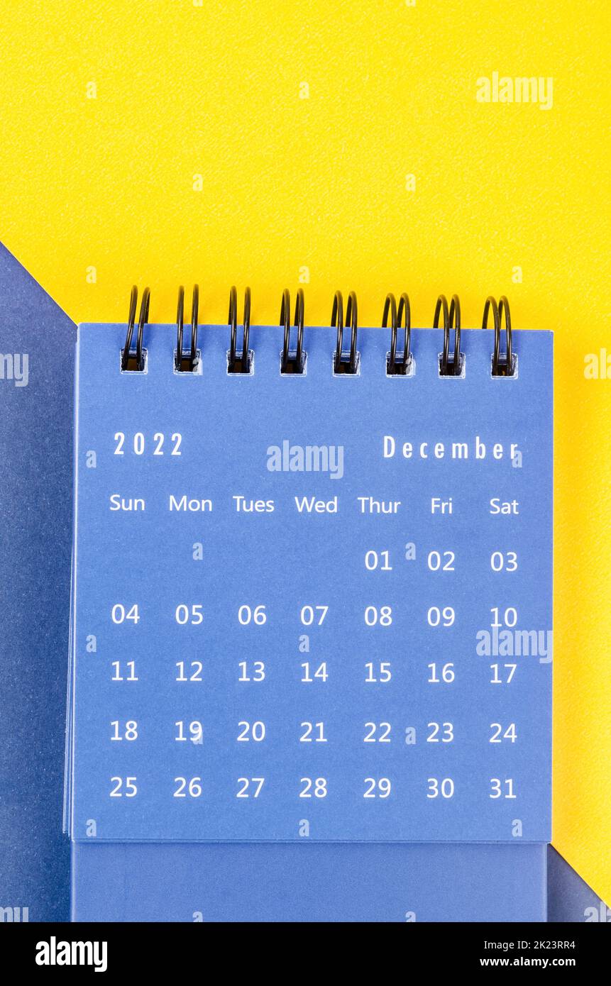 December 2022 Monthly desk calendar for 2022 year on blue and yellow background. Stock Photo