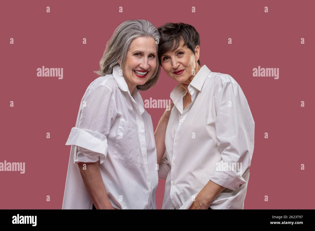 Two mature women in white shirts looking confident Stock Photo