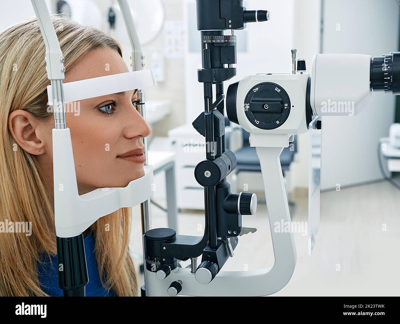 Woman getting vision test with binocular slitlamp at ophthalmology