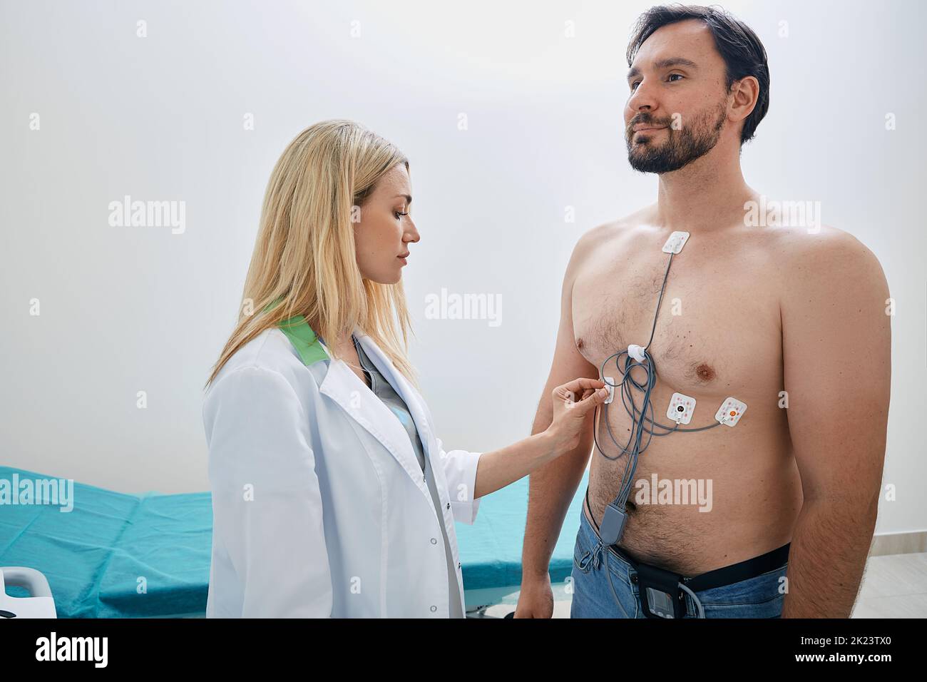 Man using Holter with ECG sensors to monitor his heart health under supervision of licensed cardiologist Stock Photo